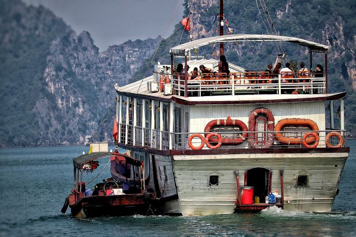 Traditional junk boat sailing among limestone karsts in Ha Long Bay